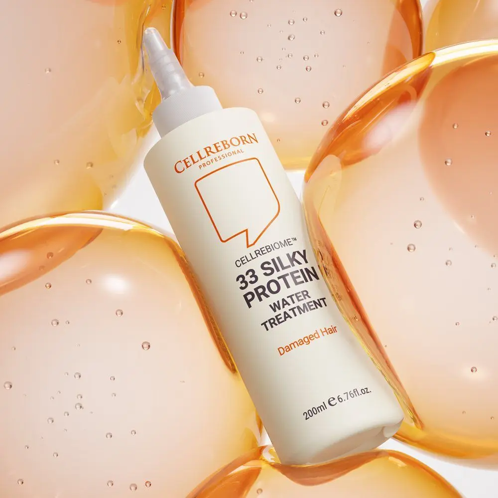 Cellrebiome 33 Silky Protein Water Treatment bottle lying among amber gel bubbles