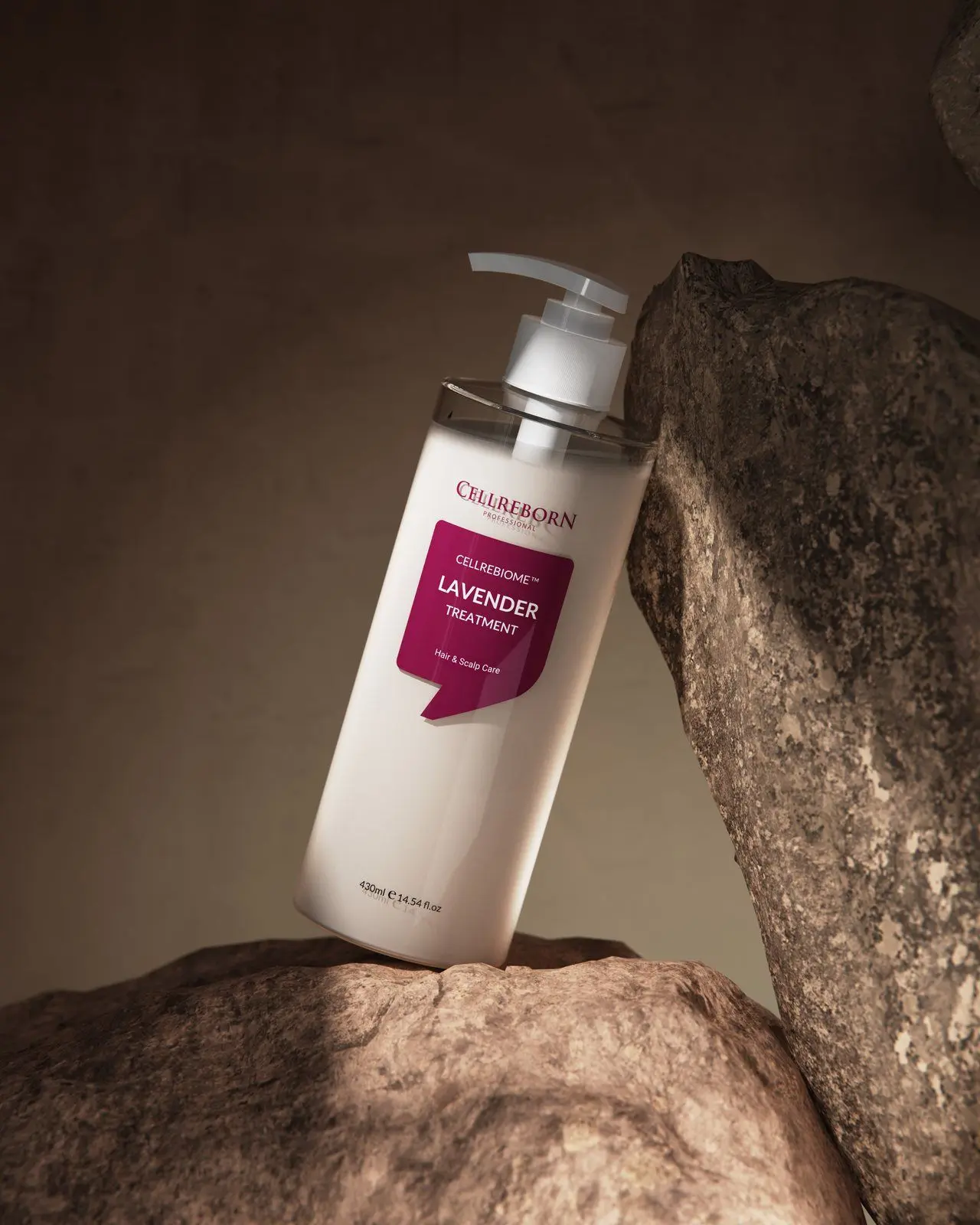 Cellrebiome Lavender Treatment bottle leaning on large brown stones in warm, low light